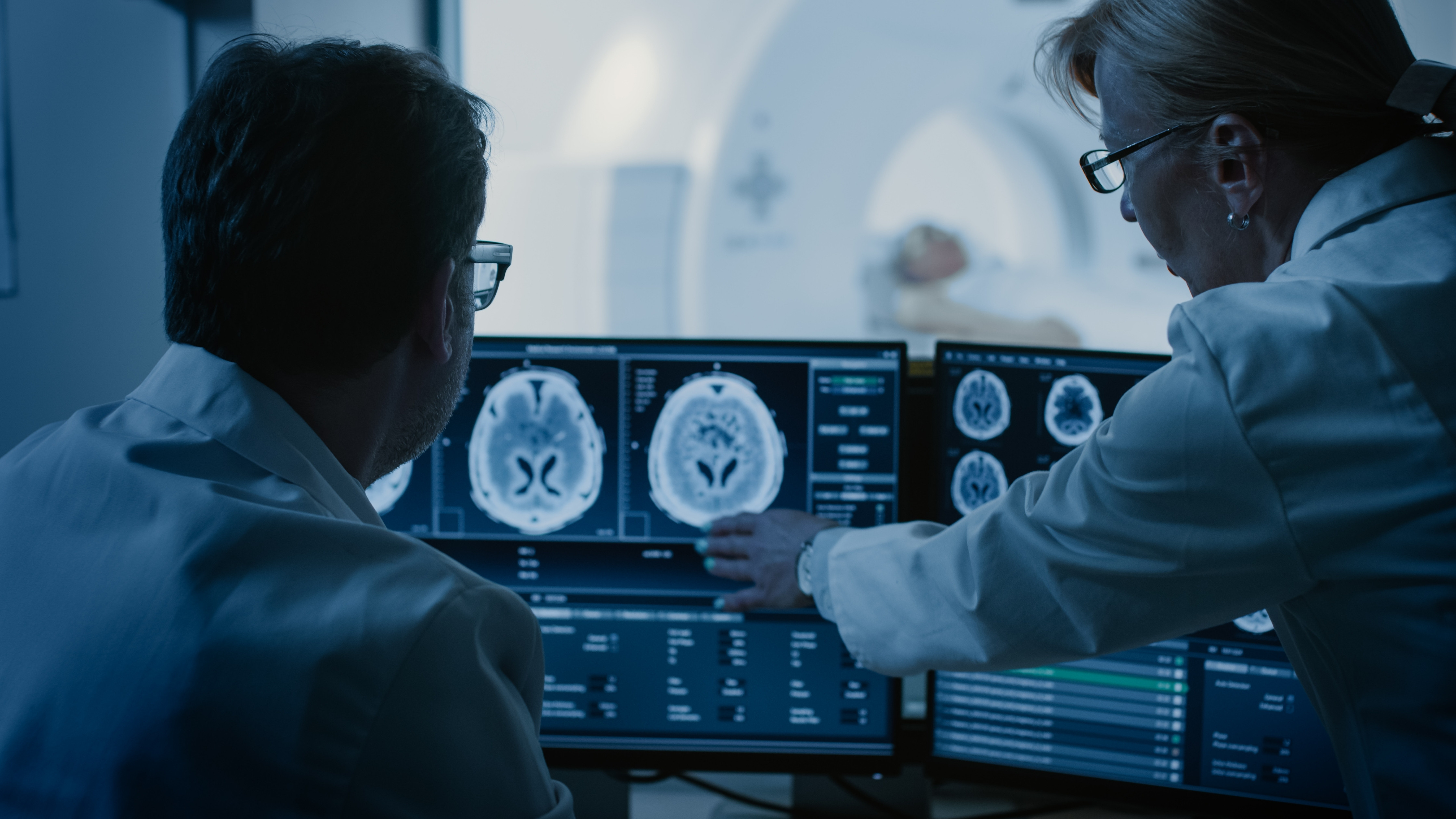 Radiologistas em sala de controle acompanhando exames em monitores